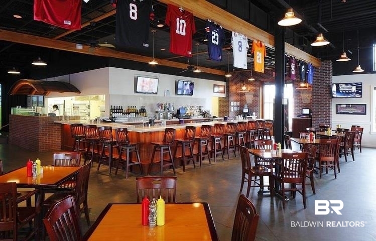 Restaurant interior with a long bar and sports jerseys hanging overhead