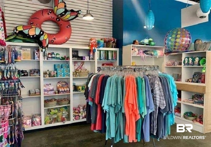 Beachwear and gift shop with colorful clothing racks, souvenir shelves, and inflatable decorations.