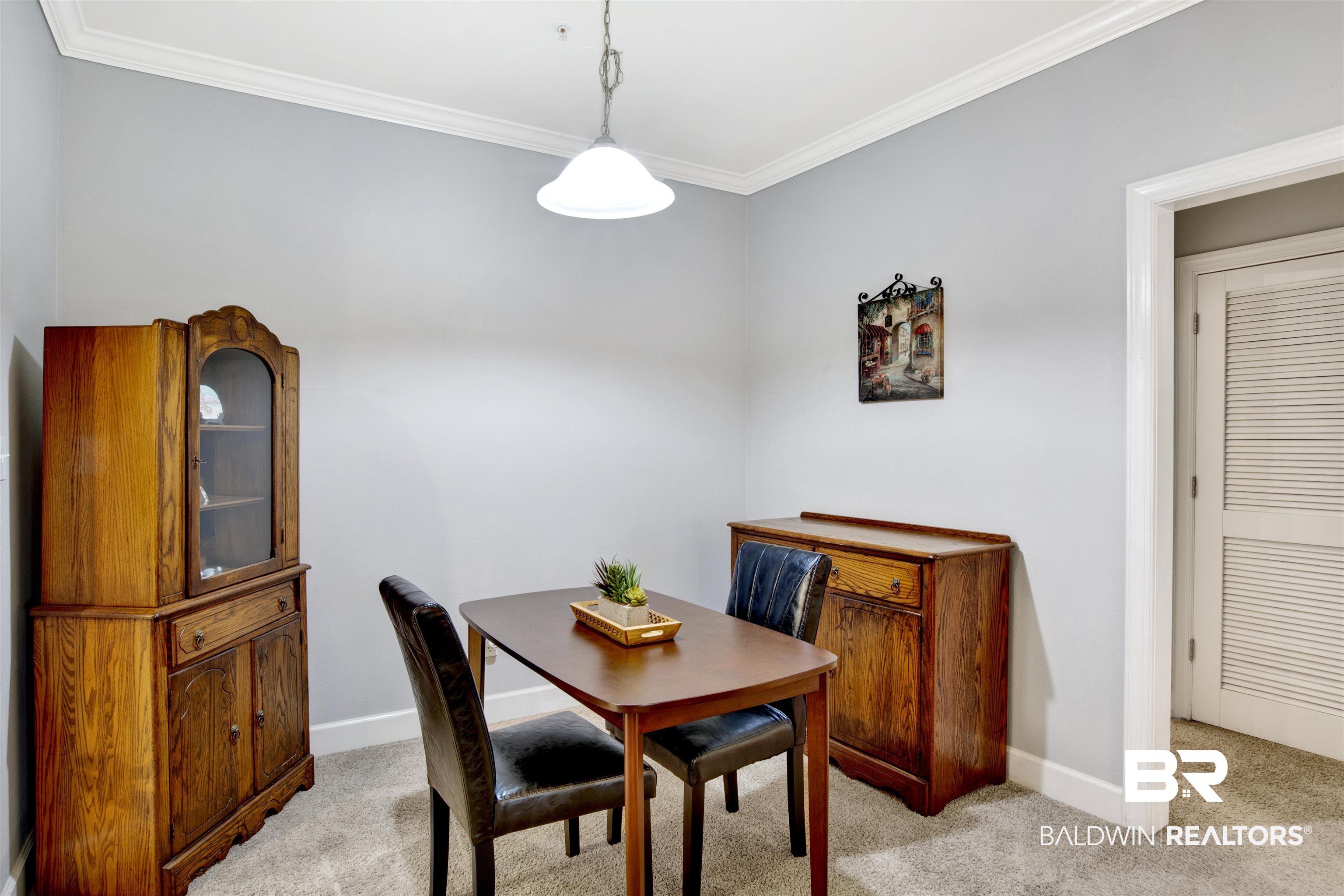 Dining room with a wooden table, black chairs, and matching china cabinet and sideboard.