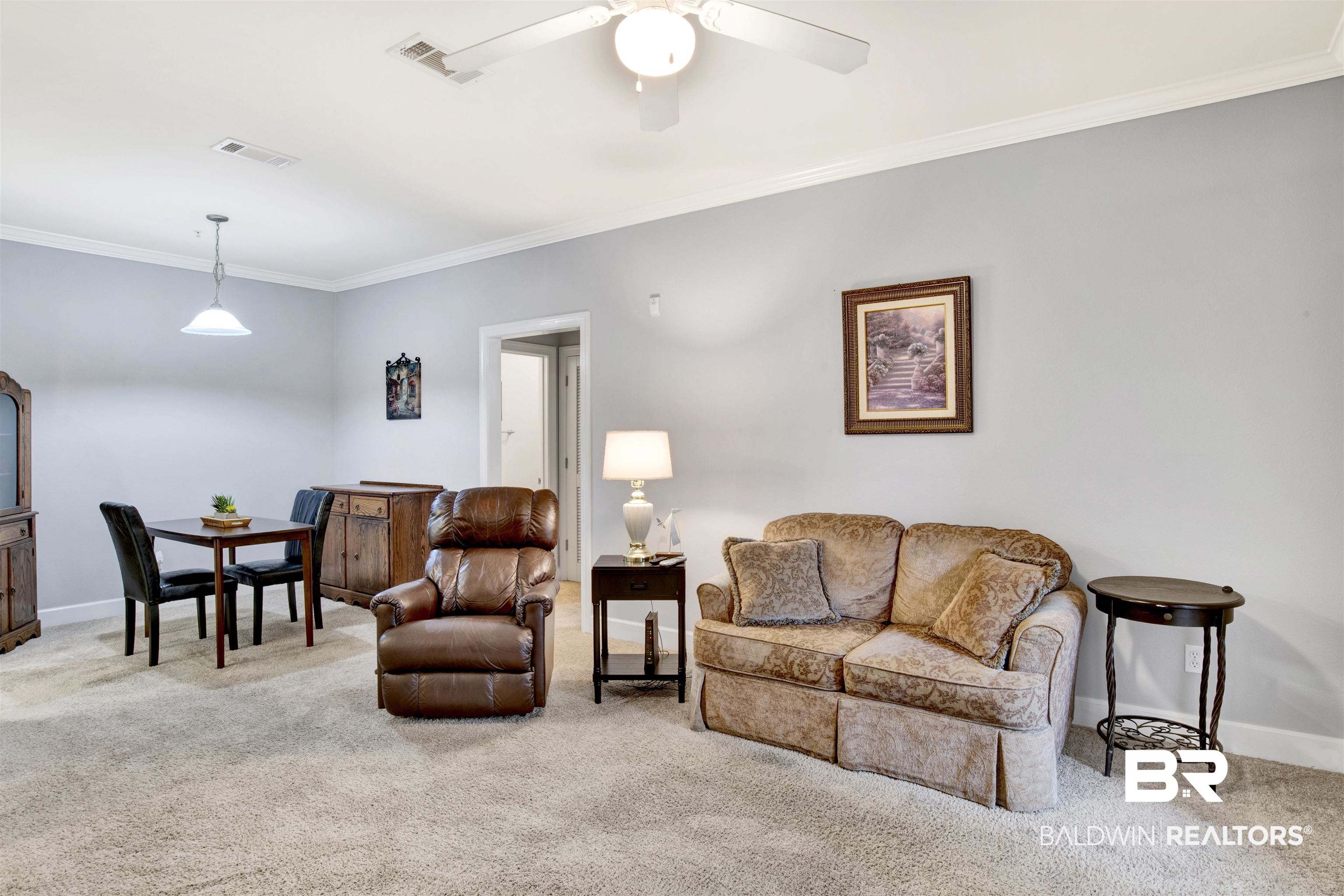 Living room with a patterned sofa, leather recliner, and dining table.
