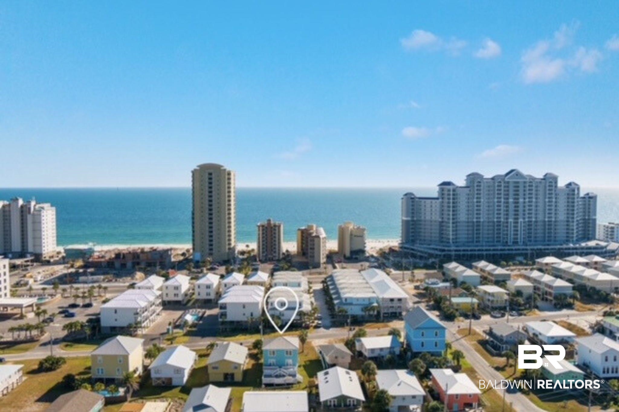 Aerial view of a Gulf Shores neighborhood, with a map pin marking a house near the beach.