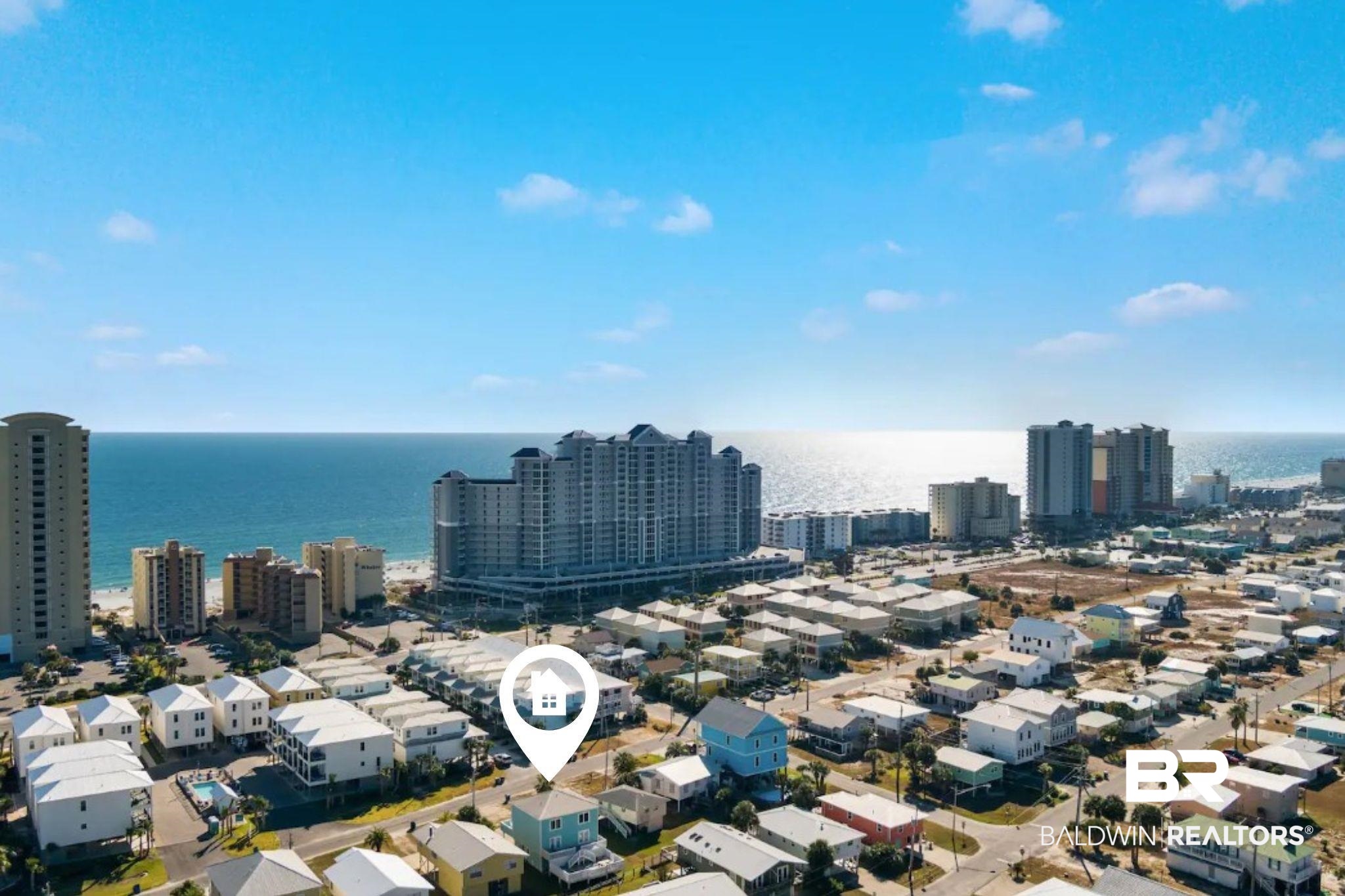 Aerial view of Gulf Shores homes and beachfront condominiums beside the Gulf of Mexico.