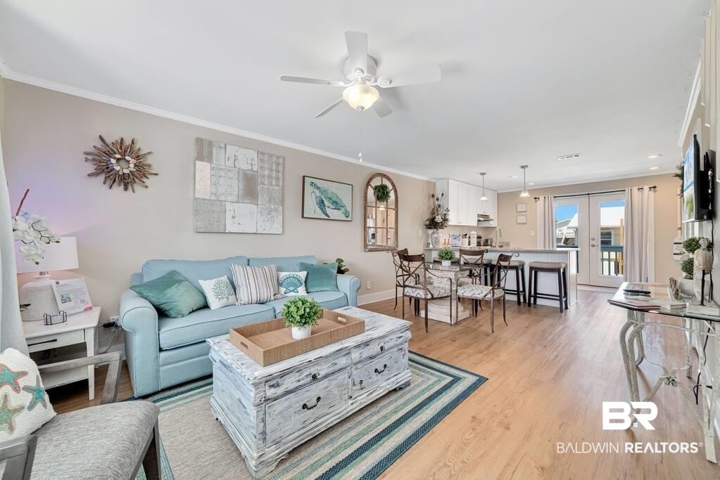 Living room with a light blue sofa and distressed white coffee table, opening to the dining area and kitchen.