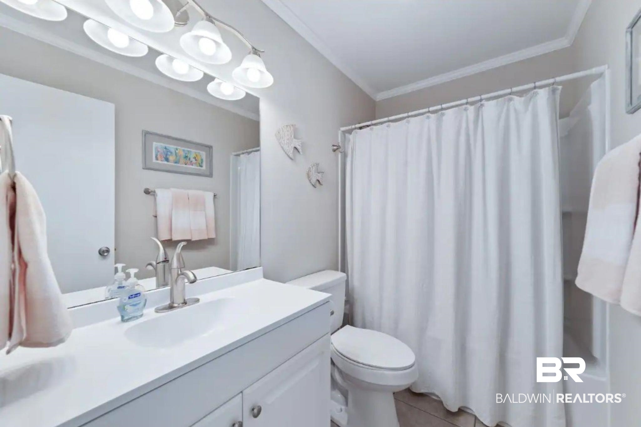 Bathroom with a white vanity, toilet, and shower curtain.