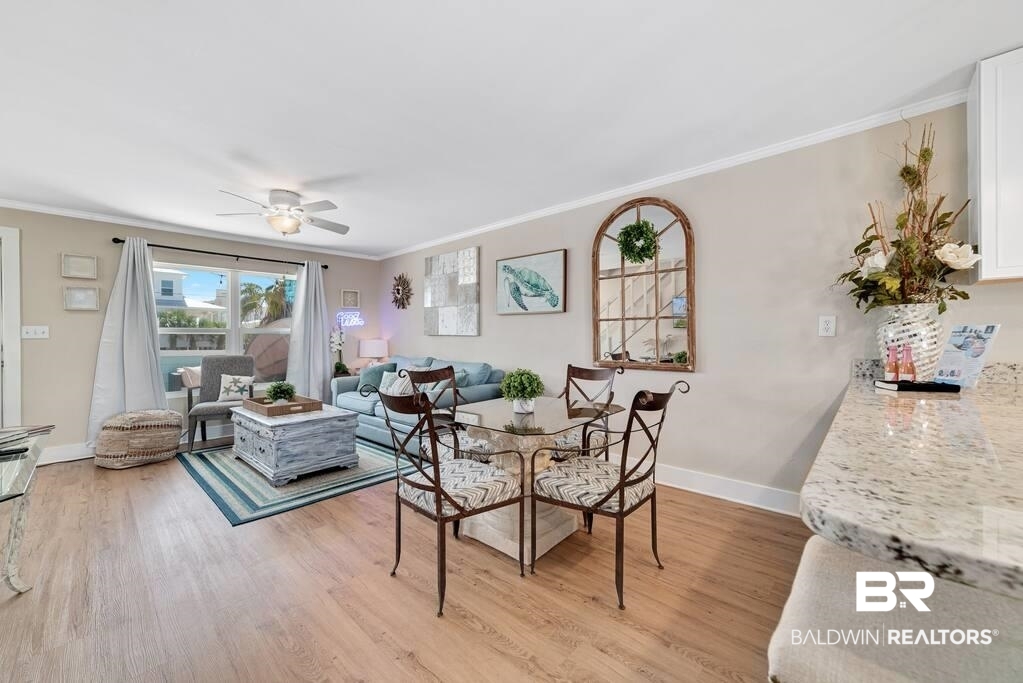 Open-plan living and dining area with a blue sofa, glass dining table, and light wood flooring.
