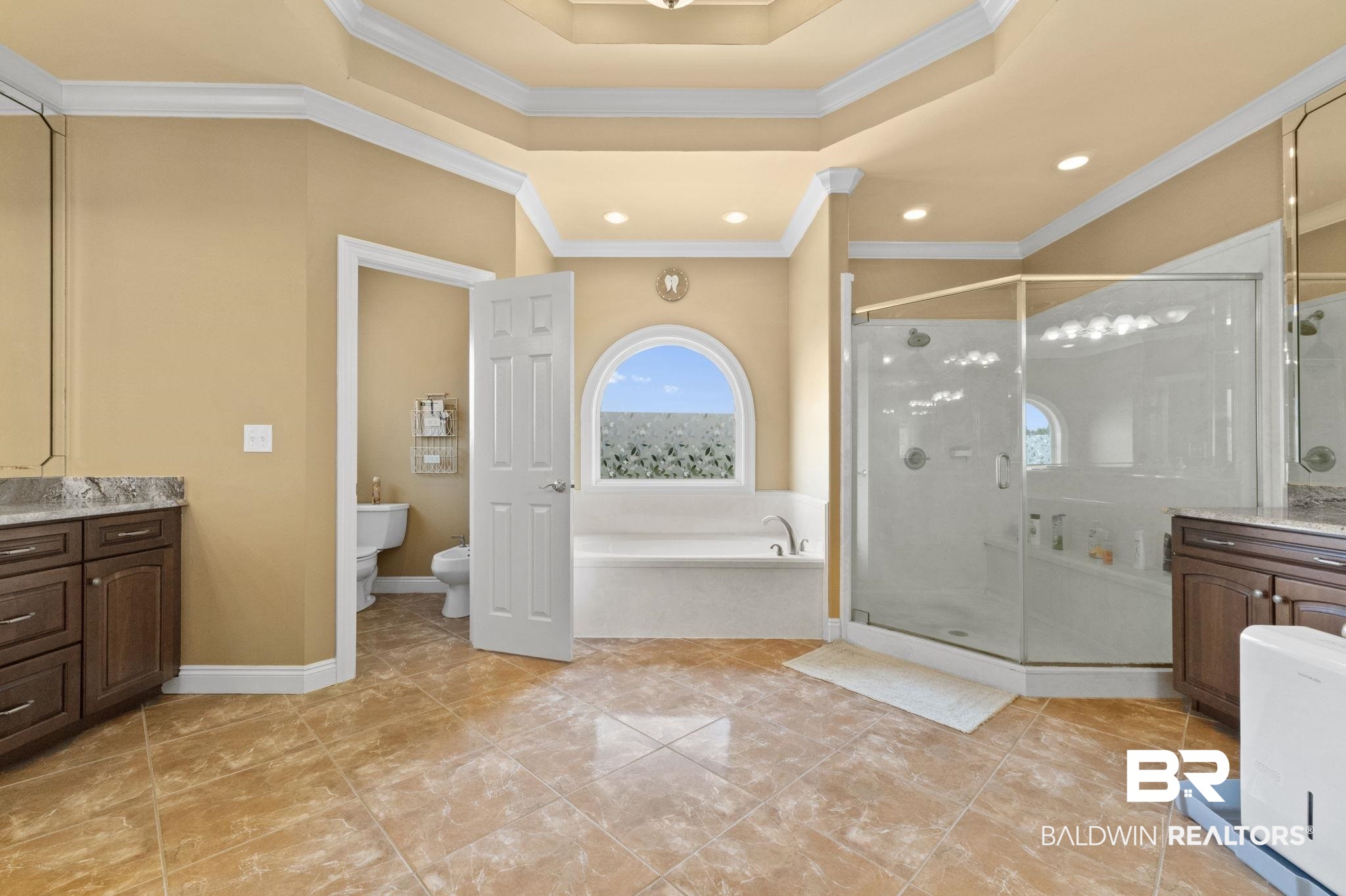 Bathroom with an arched window above the soaking tub and a large glass-enclosed shower.