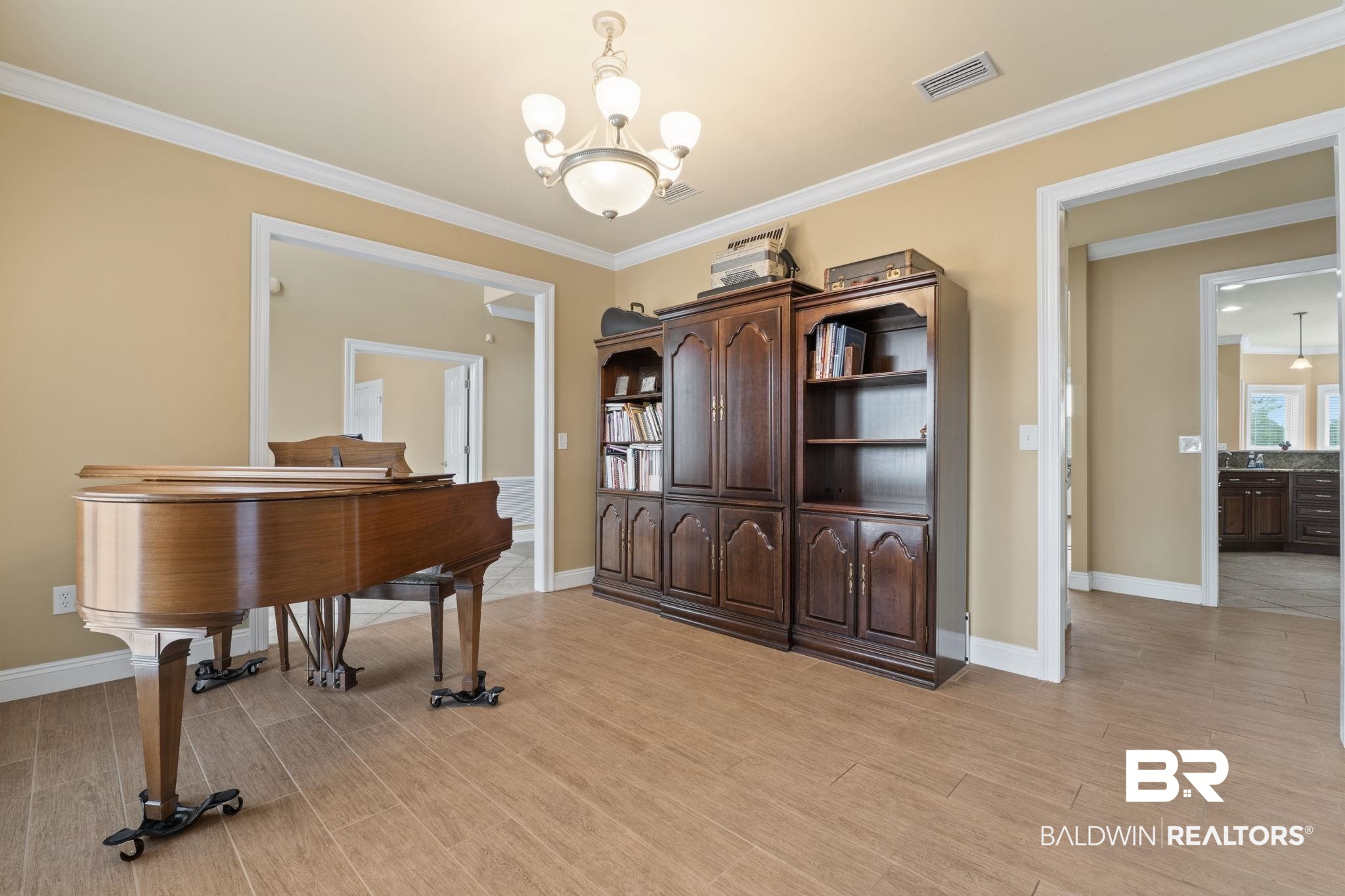 Music room with a grand piano and a large dark wood cabinet.