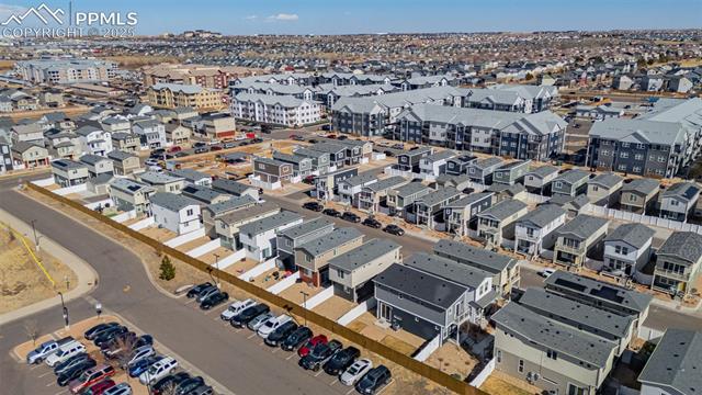 Aerial view of a residential neighborhood with rows of homes and parked cars.