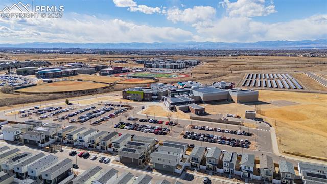 Aerial view of homes, parking lots, and commercial buildings with mountains in the distance.