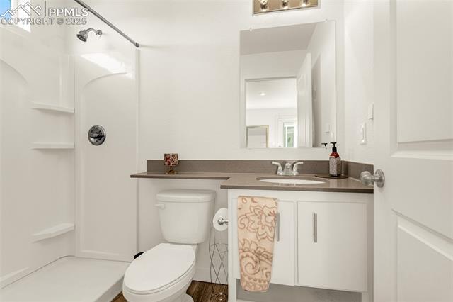 Bathroom with glass shower, built-in shelves, and a vanity with a patterned towel.