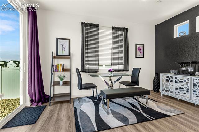 Dining area with a glass-top table, mirrored sideboard, and sliding glass door to a balcony.