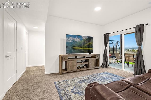 Living room with a leather sectional, television console, and sliding doors to a patio.