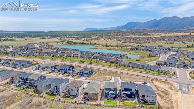 Aerial view of new homes beside a pond, with mountains in the distance.