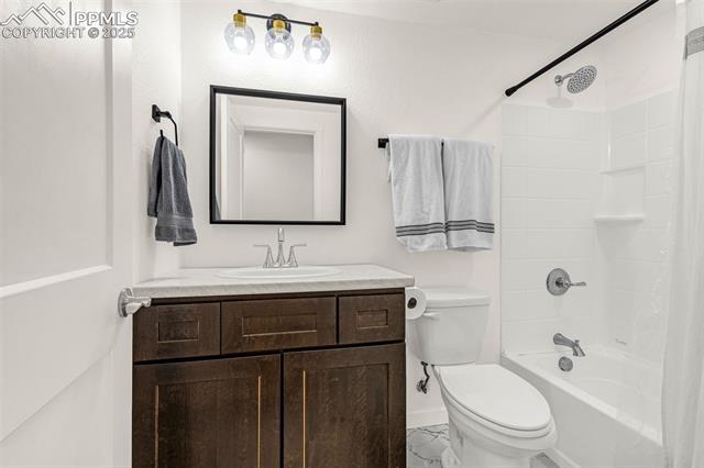 Bathroom with a dark wood vanity and white-tiled tub and shower.