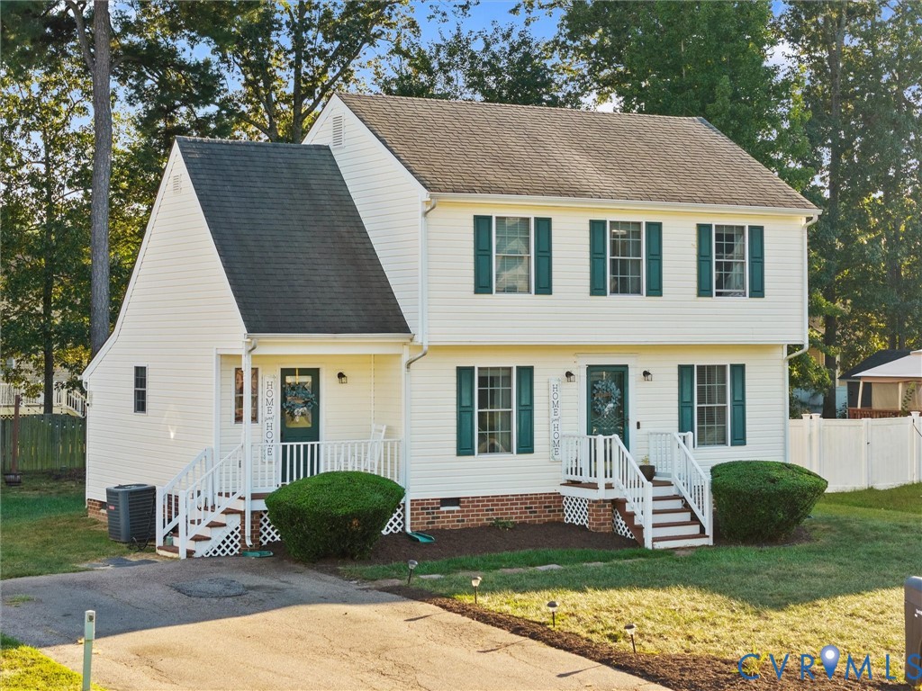 Two-story white house with green shutters, brick foundation, and two front entrances.