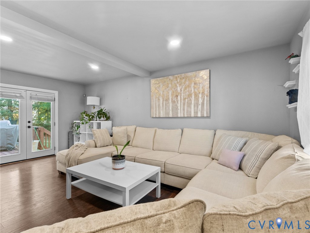 Living room with a cream sectional, white coffee table, and glass doors opening to a deck.