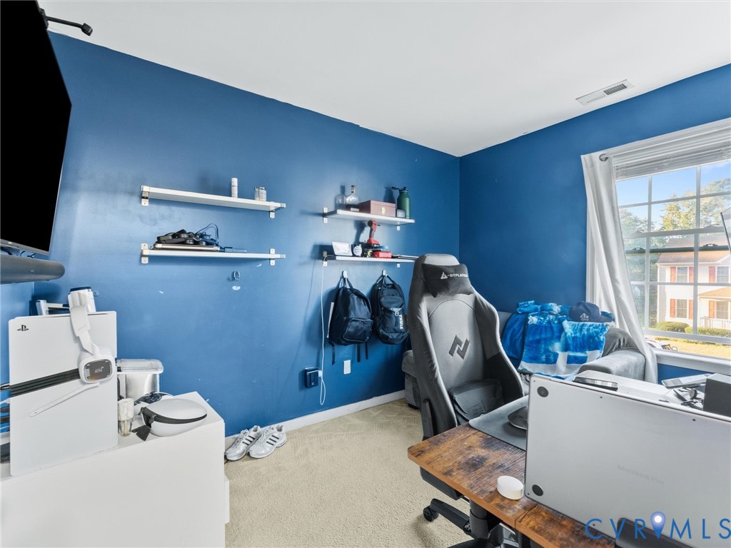 Blue gaming room with a gaming chair, computer equipment, wall shelves, and a large window.