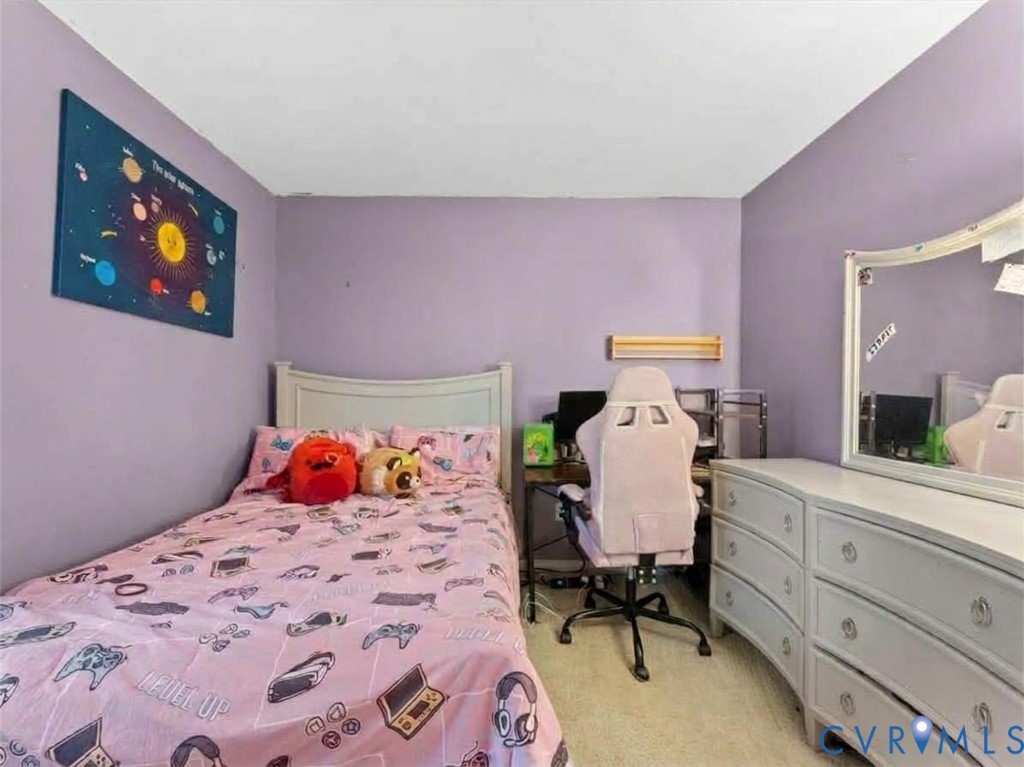 Bedroom with lavender walls, pink gaming-themed bedding, a desk and gaming chair, and a white dresser.