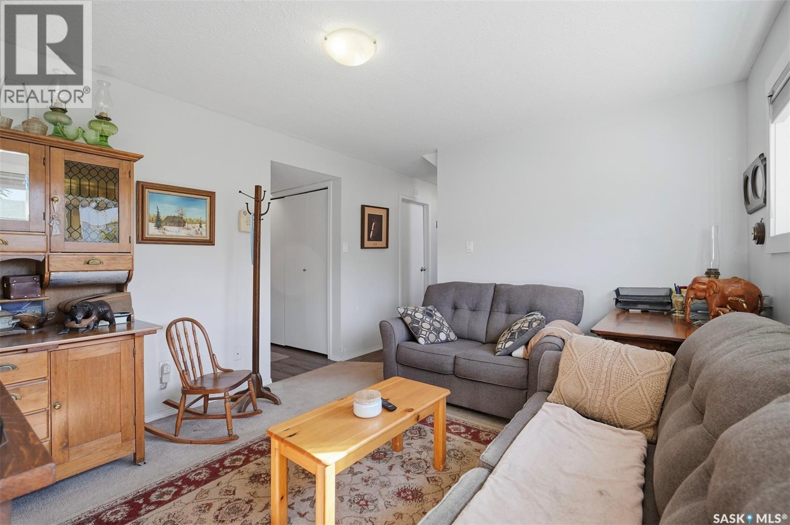 Furnished living room with gray sofas, a wooden coffee table, and an antique cabinet.