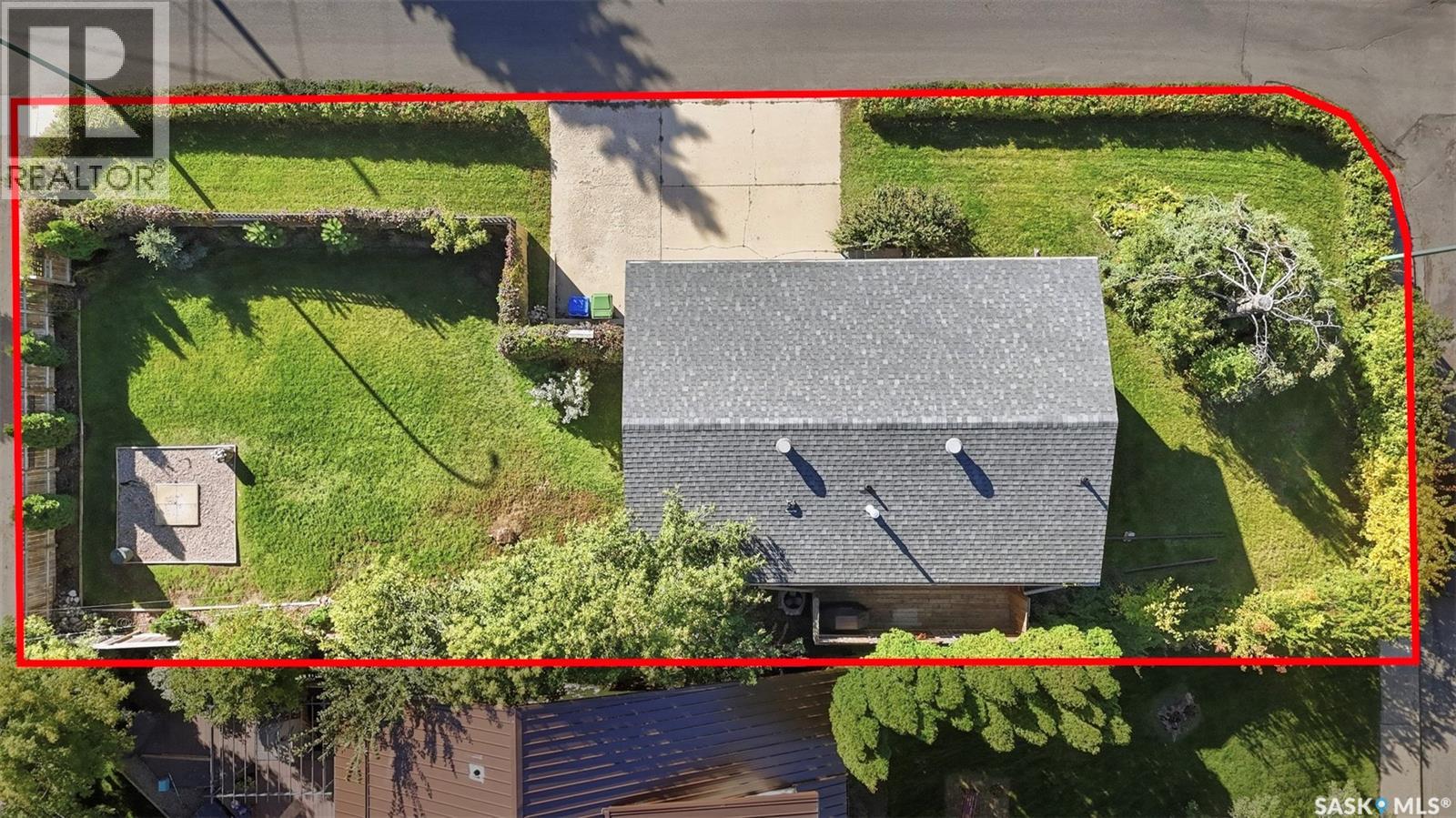 Aerial view of the property lot outlined in red, showing the house, lawn, and driveway.
