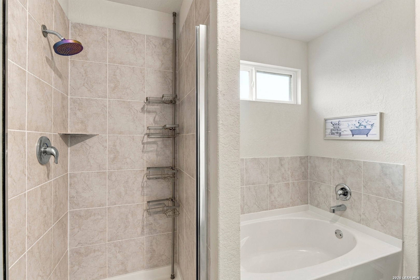 Bathroom with a tiled walk-in shower beside a white corner soaking tub.