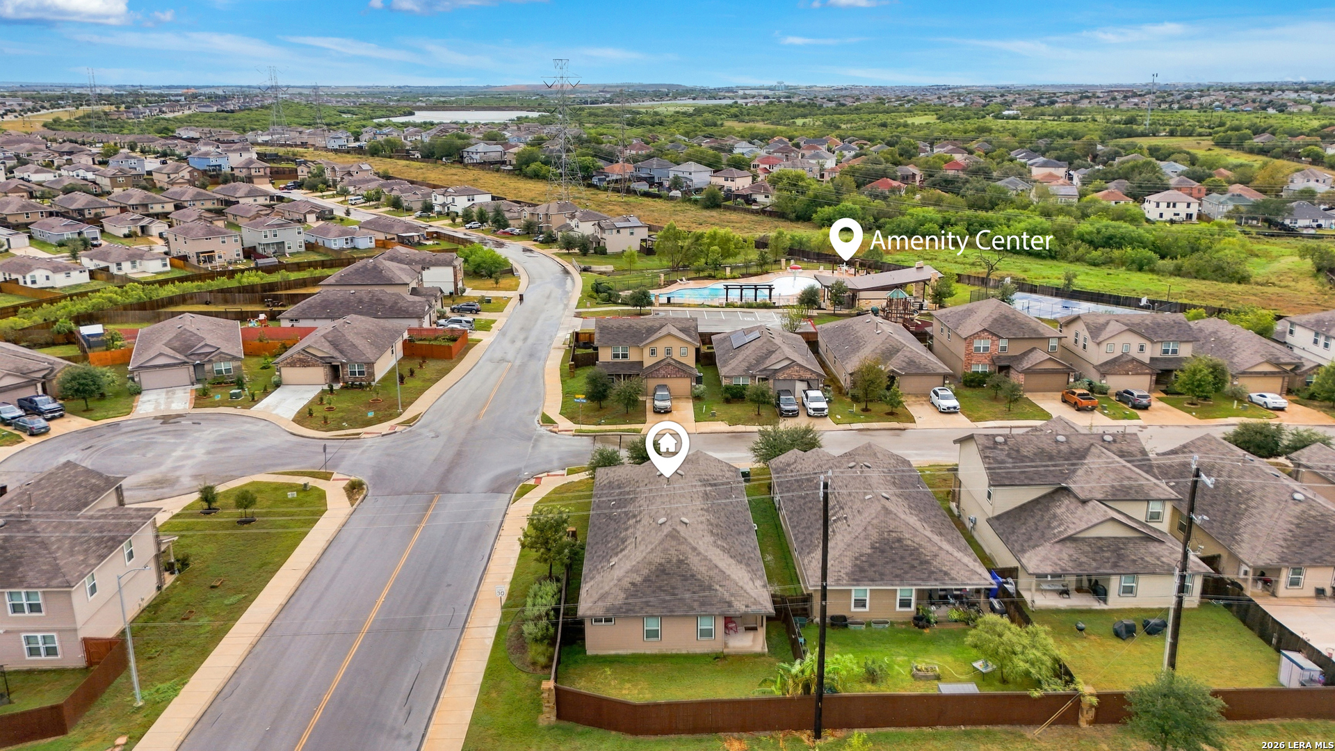 Aerial neighborhood view marking the home and an amenity center with a pool.