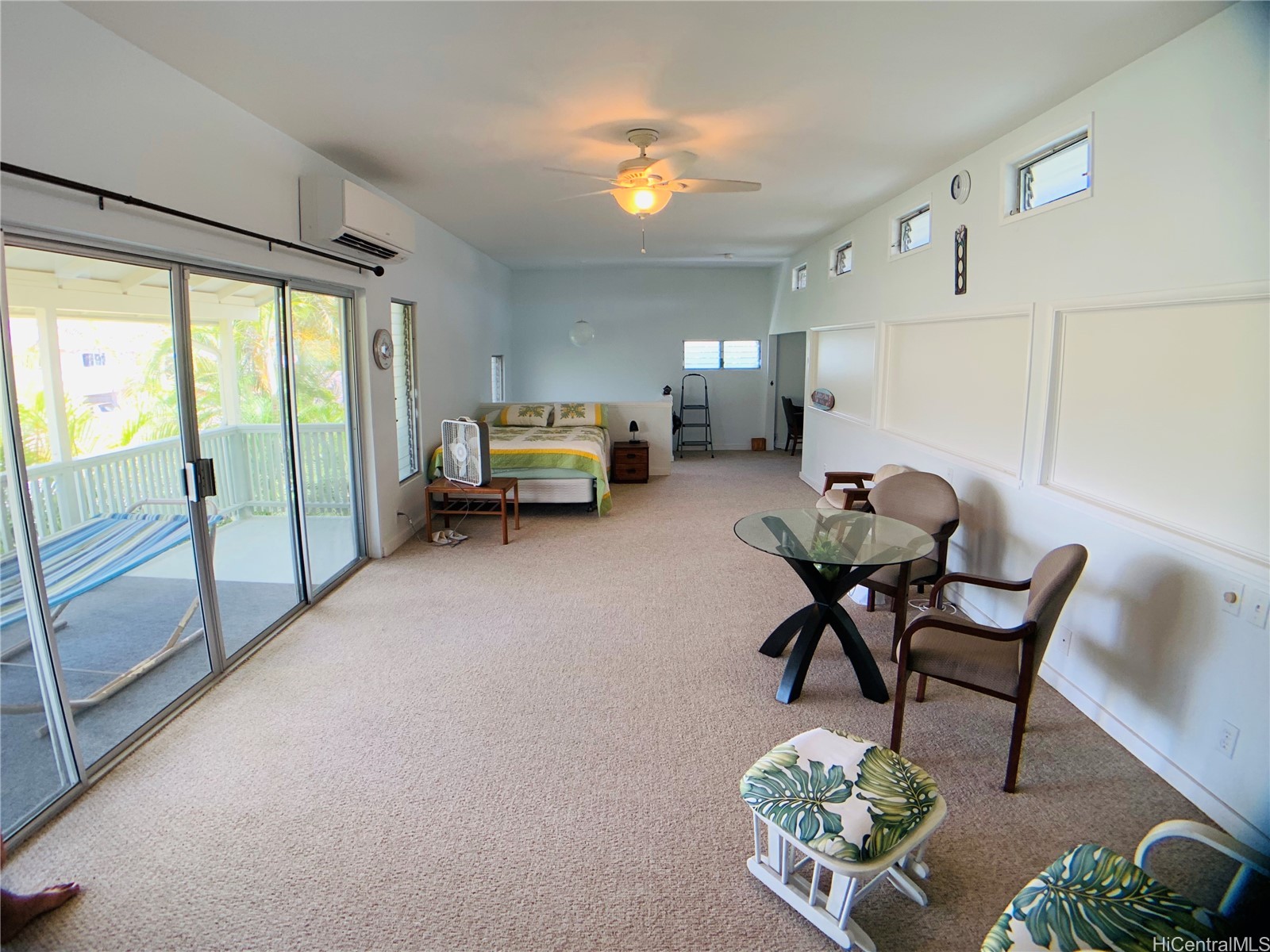 Furnished bedroom and sitting area with sliding glass doors opening to a covered lanai.