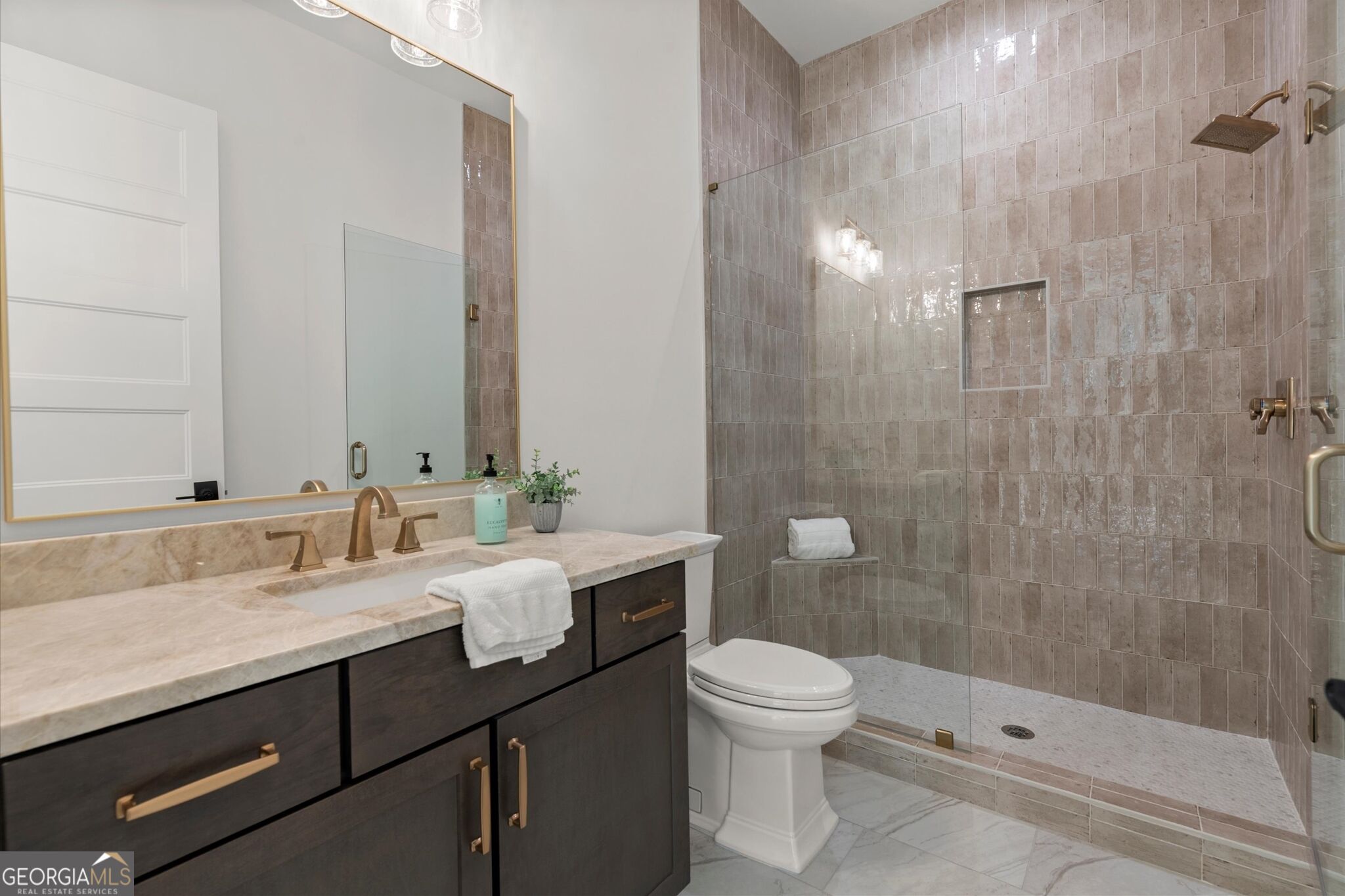 Modern bathroom with a dark wood vanity and a glass-enclosed tiled shower.