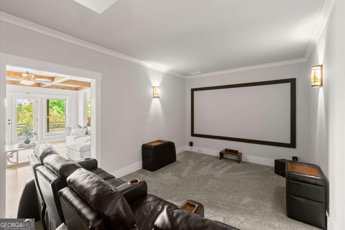 Home theater with a large projection screen, gray carpet, and leather recliners.