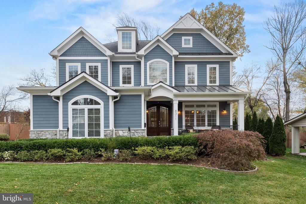 Blue-gray two-story house with white trim, multiple gables, and a covered front porch.