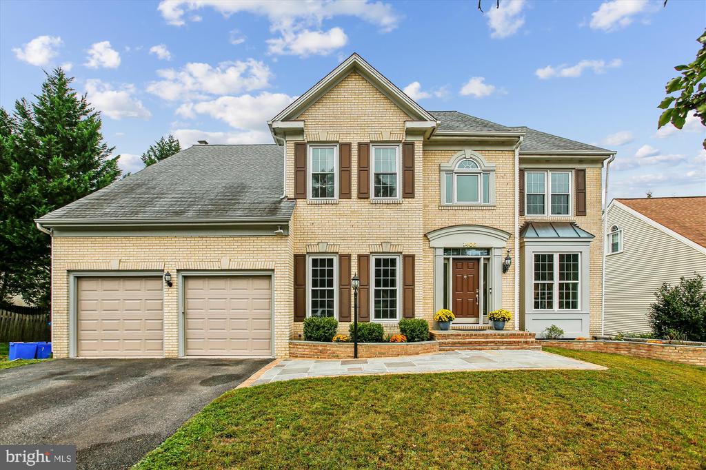 Two-story brick house with a two-car garage and landscaped front entry.