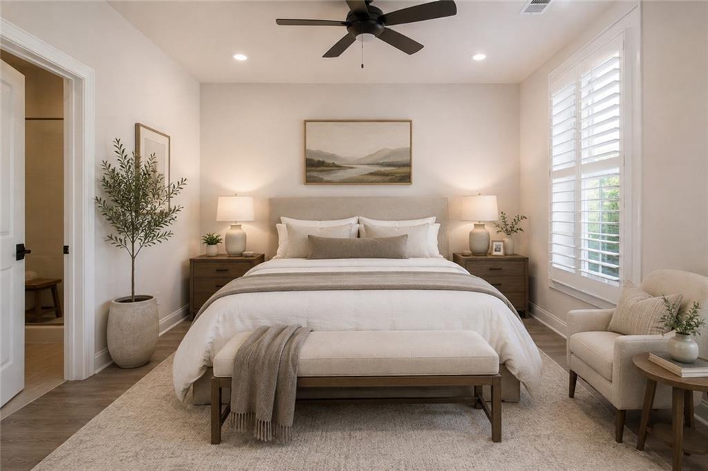 Staged bedroom with a large bed, upholstered bench, and bright plantation-shuttered window.