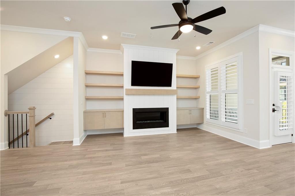 Living room with built-in shelves, fireplace, and wall-mounted television.