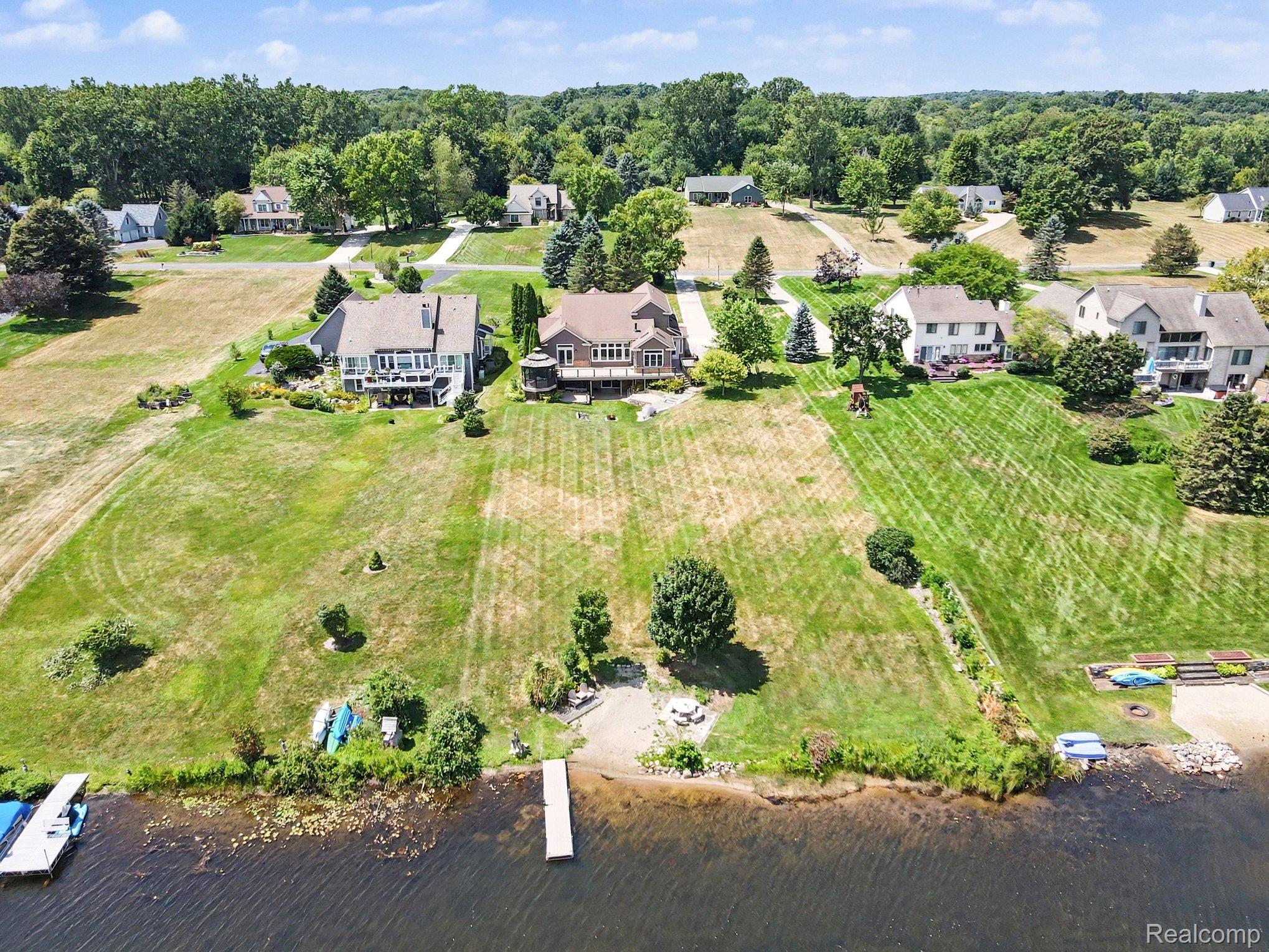Waterfront home with a broad lawn and dock extending into the lake.