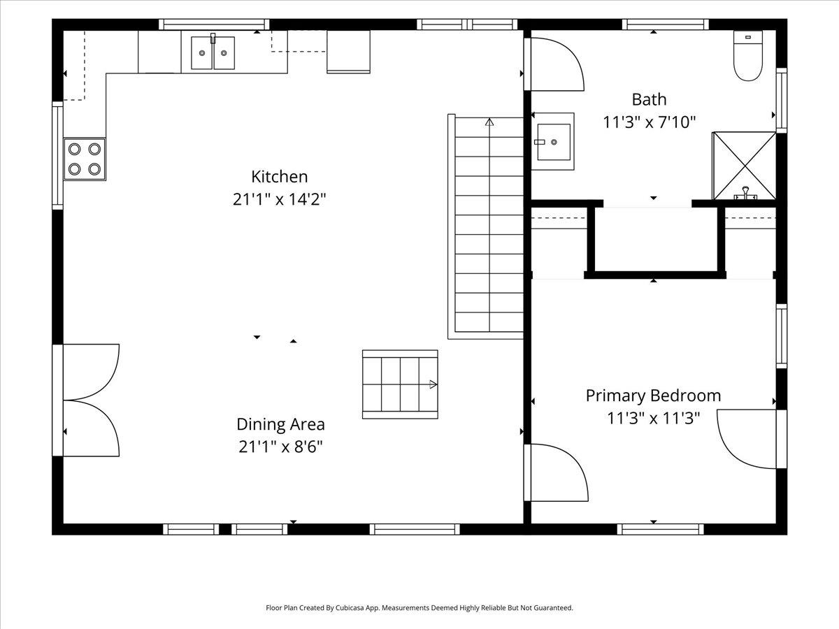 Floor plan showing the kitchen, dining area, primary bedroom, bath, and central staircase.
