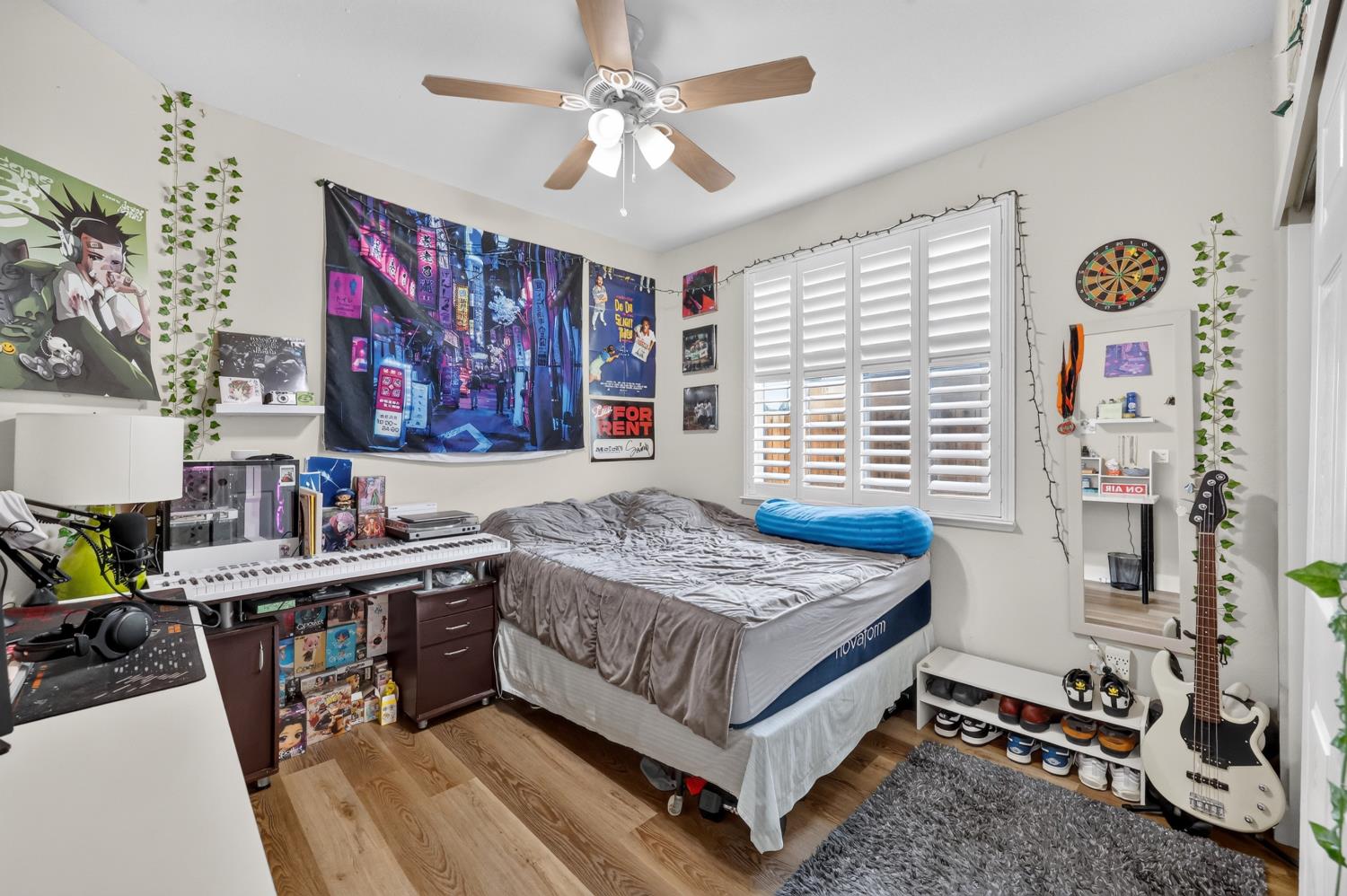 Furnished bedroom with a bed, shuttered windows, keyboard, and electric guitar.