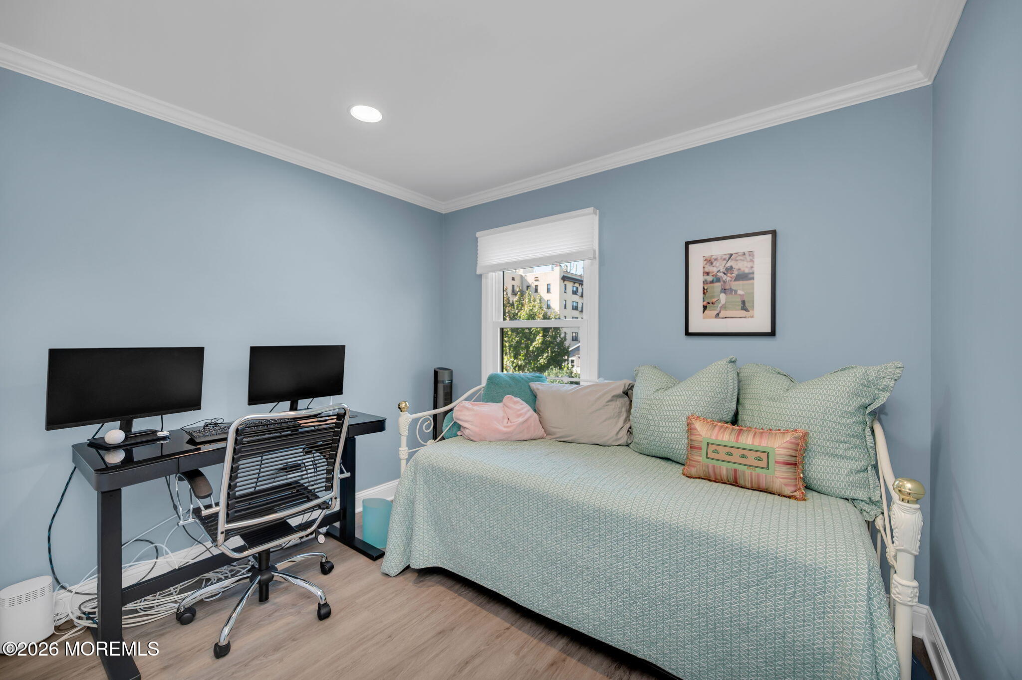 Bedroom with an aqua-covered daybed beside a black desk and dual monitors.