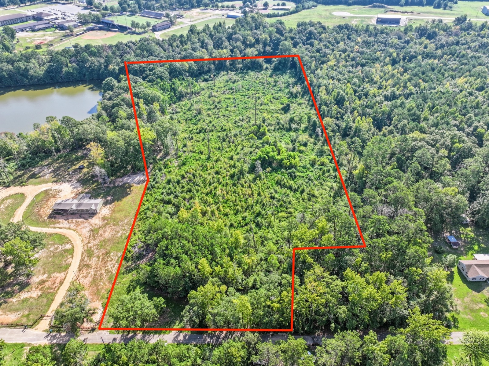 Wooded parcel outlined in red beside a lake, viewed from above.