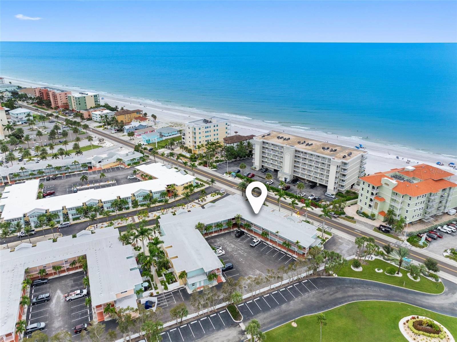 Aerial view of beachfront condos along the Gulf, with a location marker over the property.