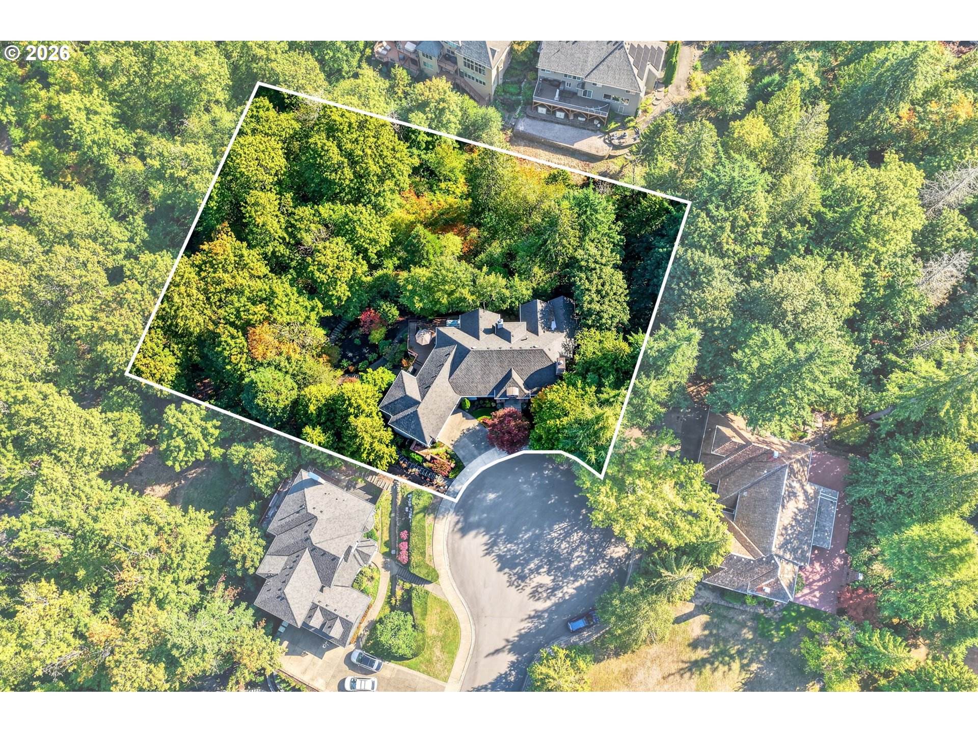 Aerial view of a wooded home lot outlined in white beside a cul-de-sac.