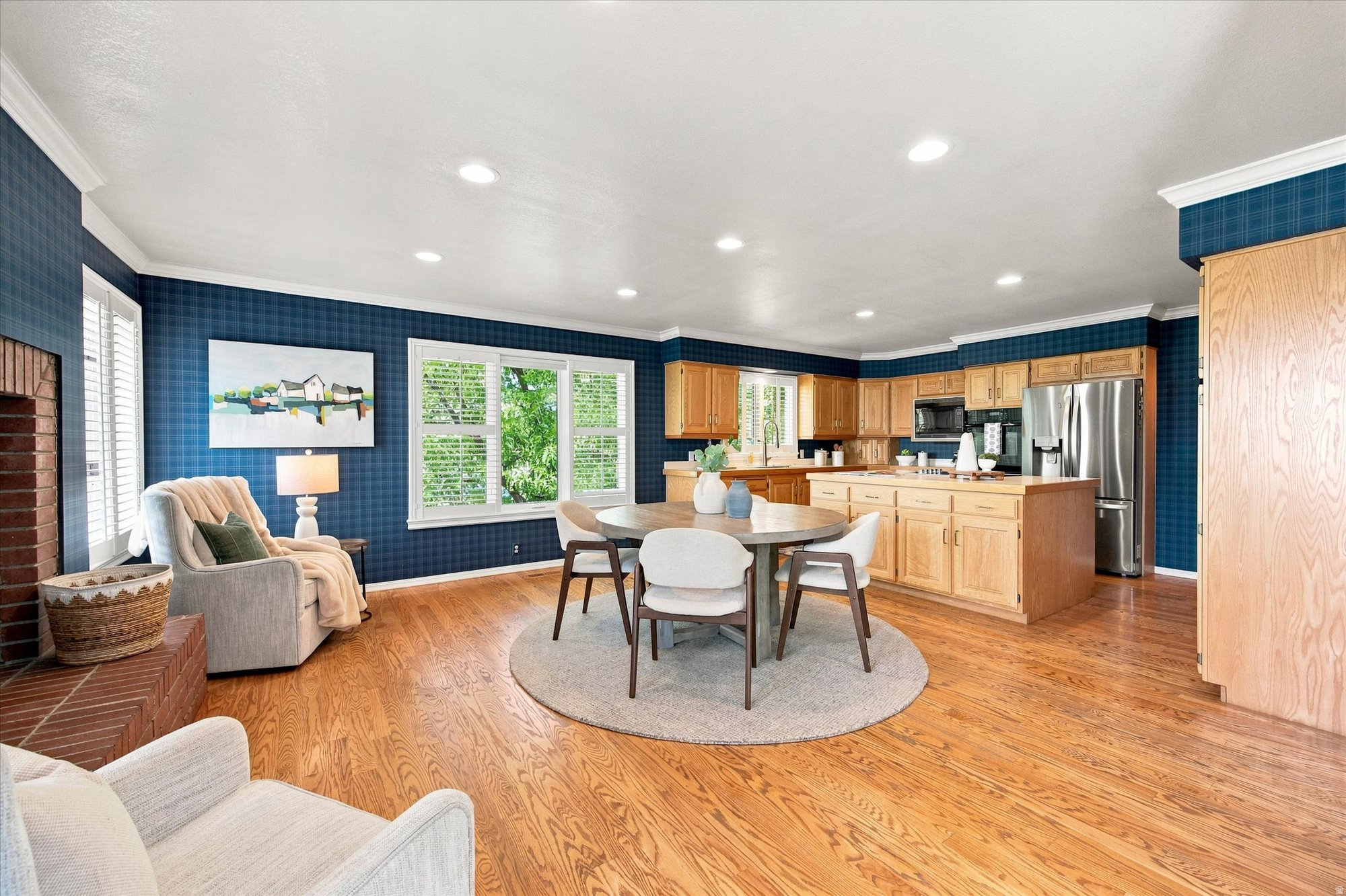 Open kitchen and dining area with blue walls, wood cabinetry, and an adjoining sitting space.