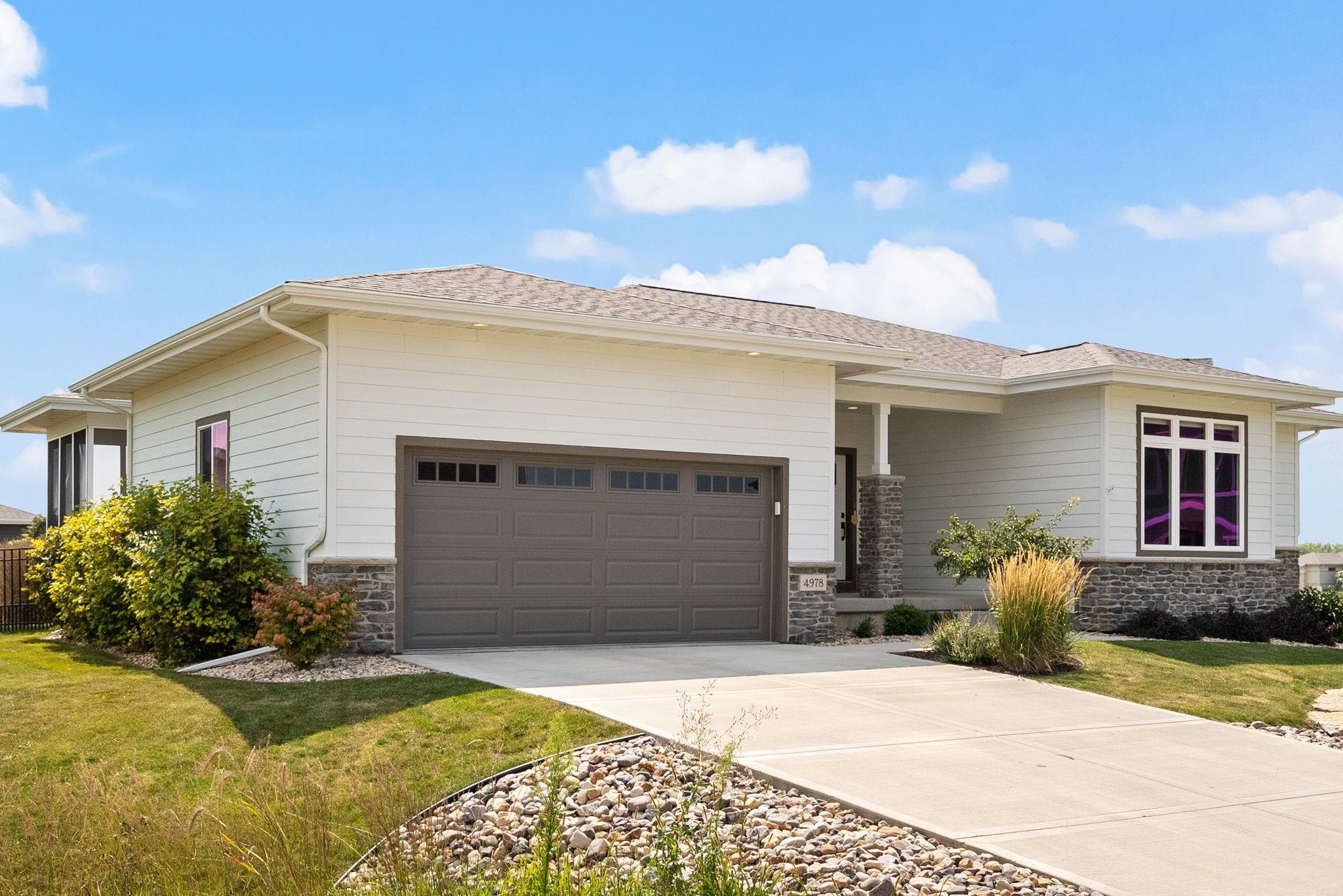 Single-story home with a stone-accented exterior, wide garage, and landscaped front yard.
