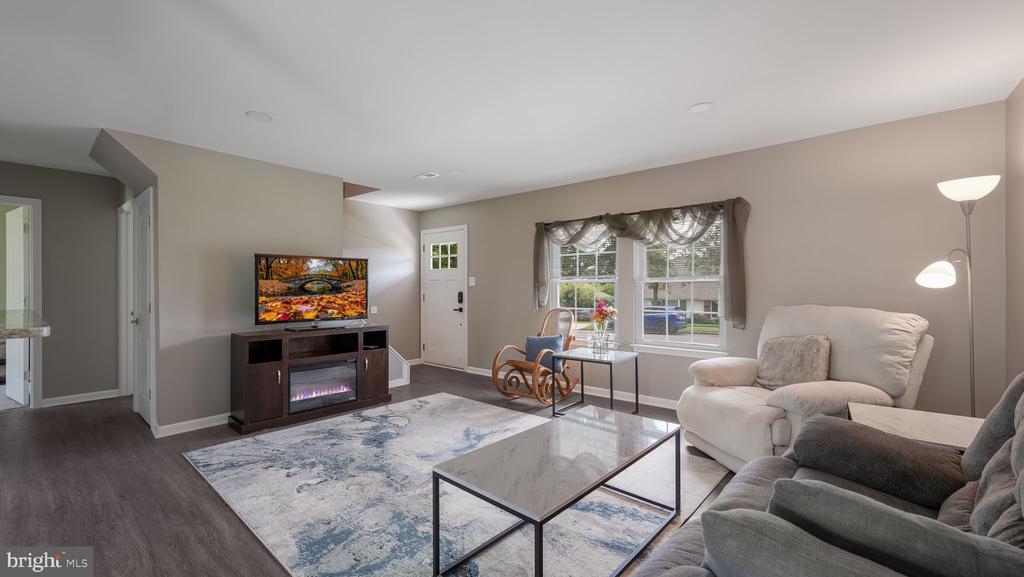 Living room with a marble-top coffee table, blue-and-white rug, and TV above an electric fireplace.