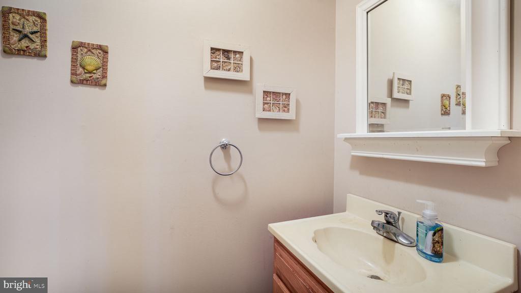 Bathroom vanity with a large wall mirror, chrome faucet, and decorative wall art.