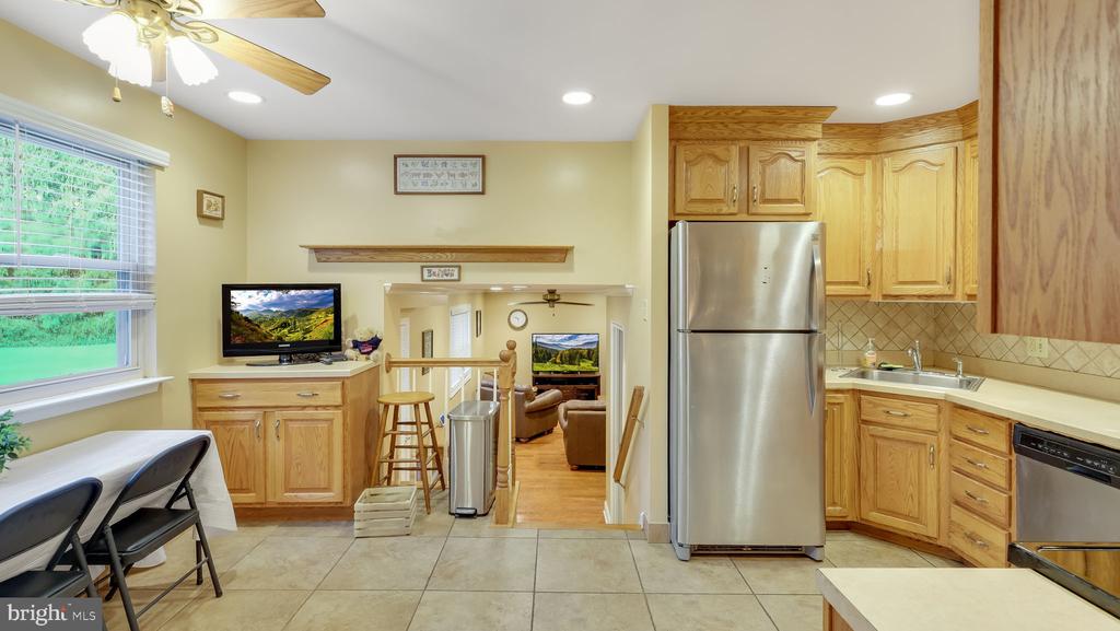 Kitchen with oak cabinets and stainless steel appliances, opening into the living room.