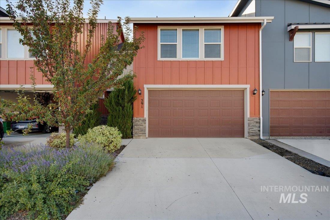 Coral-sided two-story home with a double garage, stone accents, and landscaped frontage.