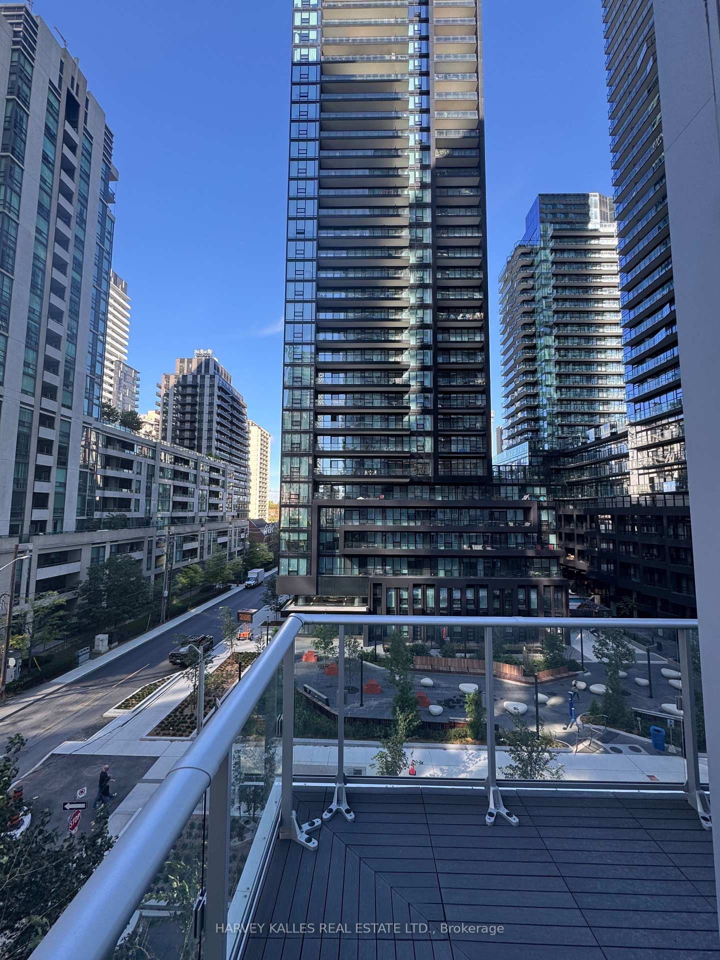 Condo balcony overlooking a landscaped courtyard and surrounding high-rise buildings.