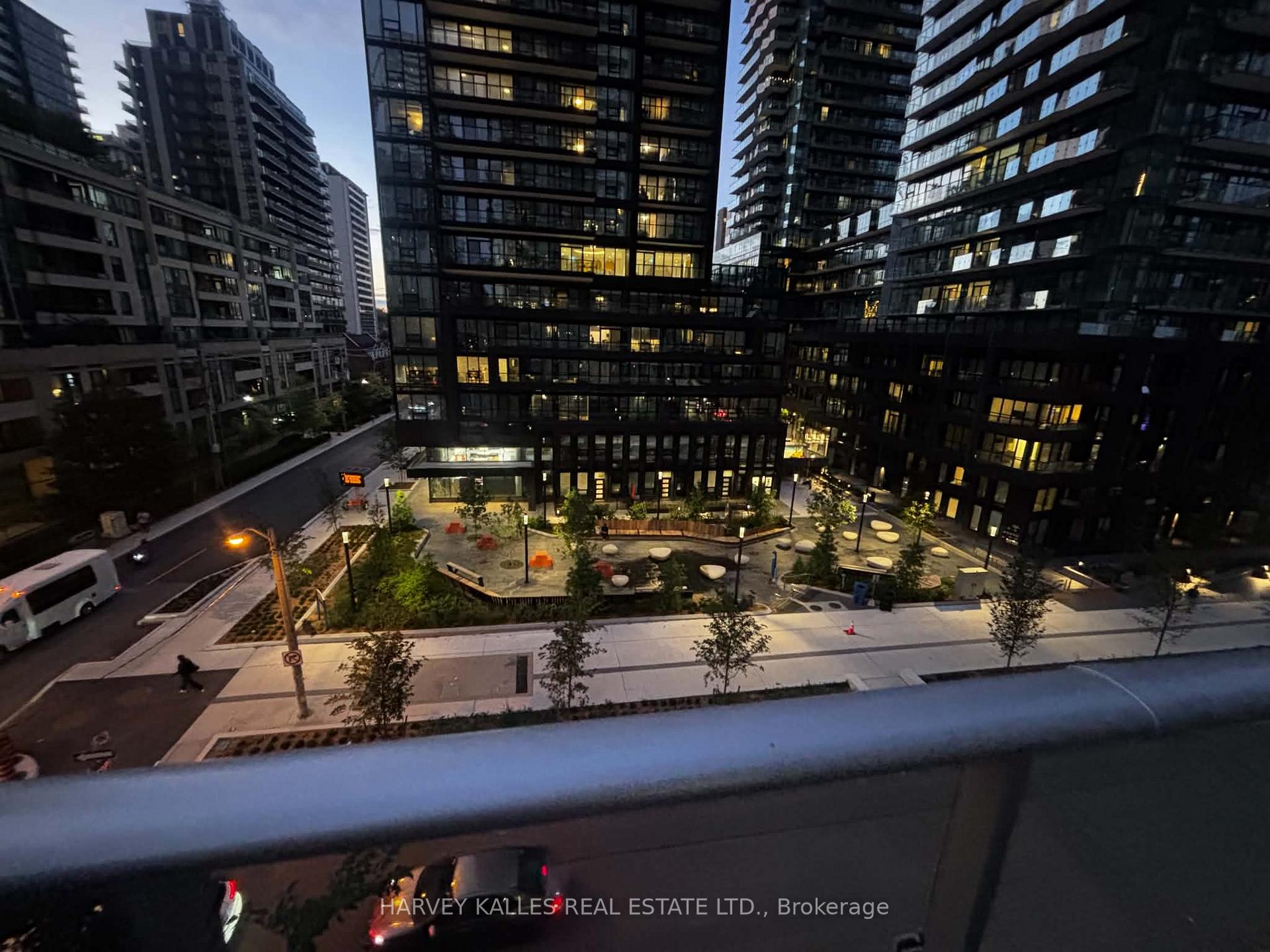 Dusk view over a landscaped condo courtyard surrounded by illuminated high-rise buildings.