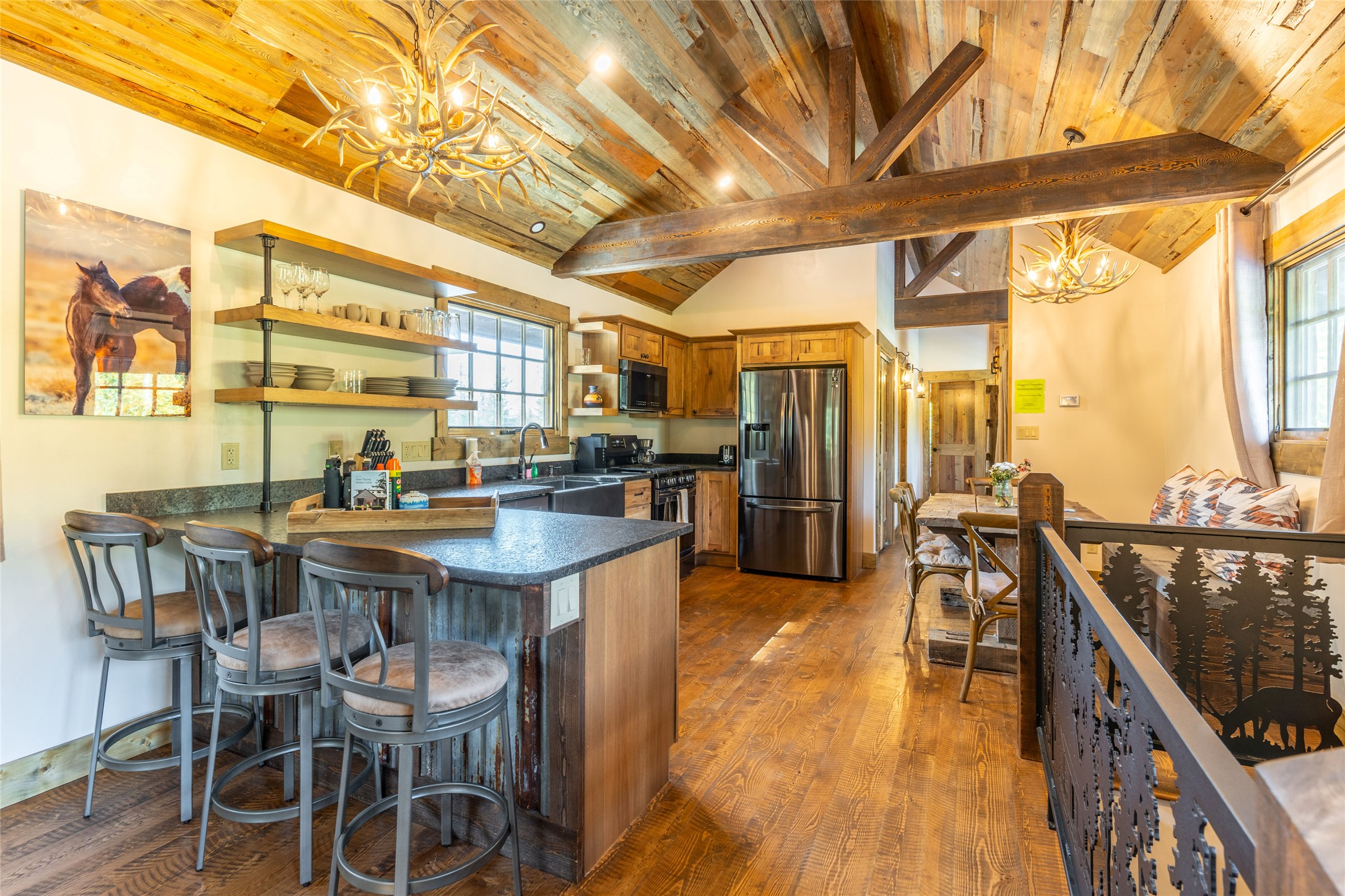 Rustic kitchen with a large island, exposed timber ceiling, and adjoining dining area.