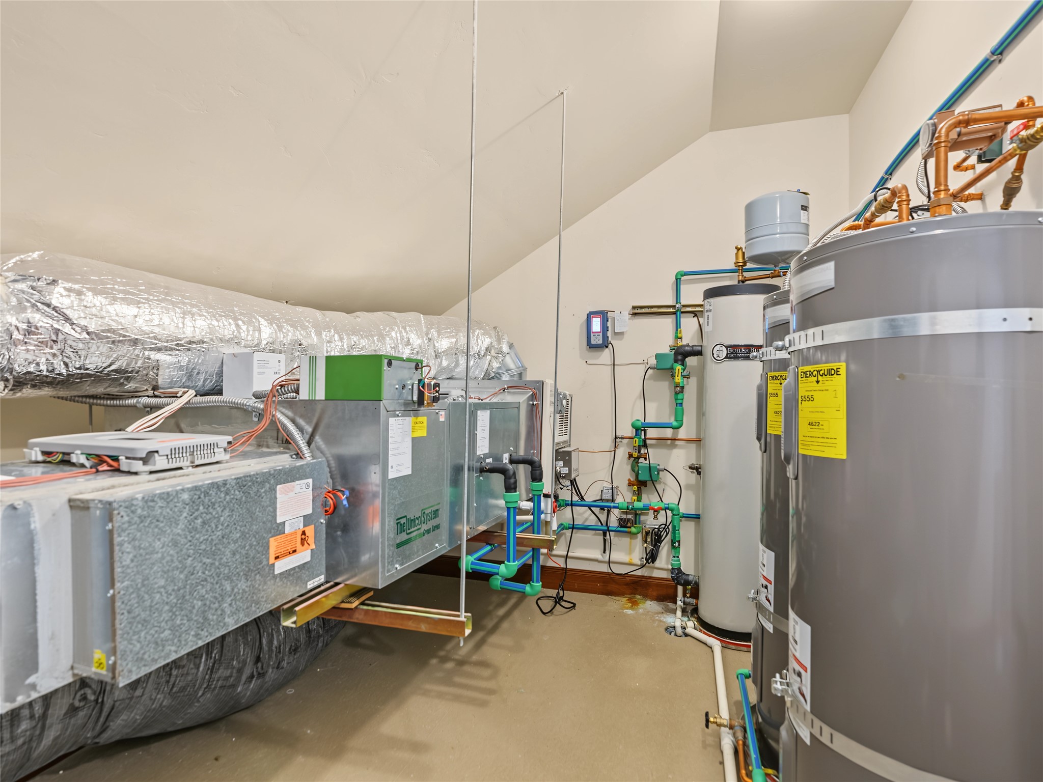Mechanical room with HVAC equipment, insulated ductwork, and several large water heaters.